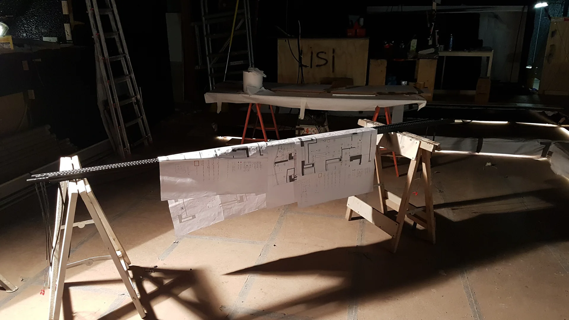 Execution drawings laid over sawhorses on site during installation and commissioning of a spatial media system