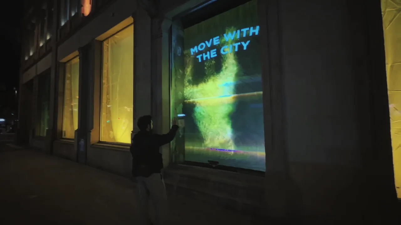 Pedestrian interacting with fluid waves of light on a glass shopfront in Luxembourg